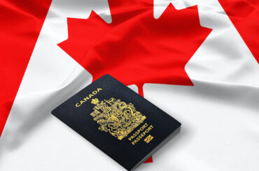 passport of Canada on the top of an satin canadian flag